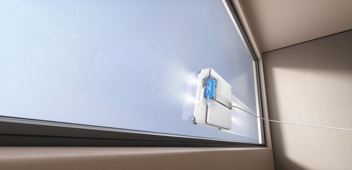 Robot lave-vitres MOVA en train de nettoyer une vitre grâce à sa brumisation